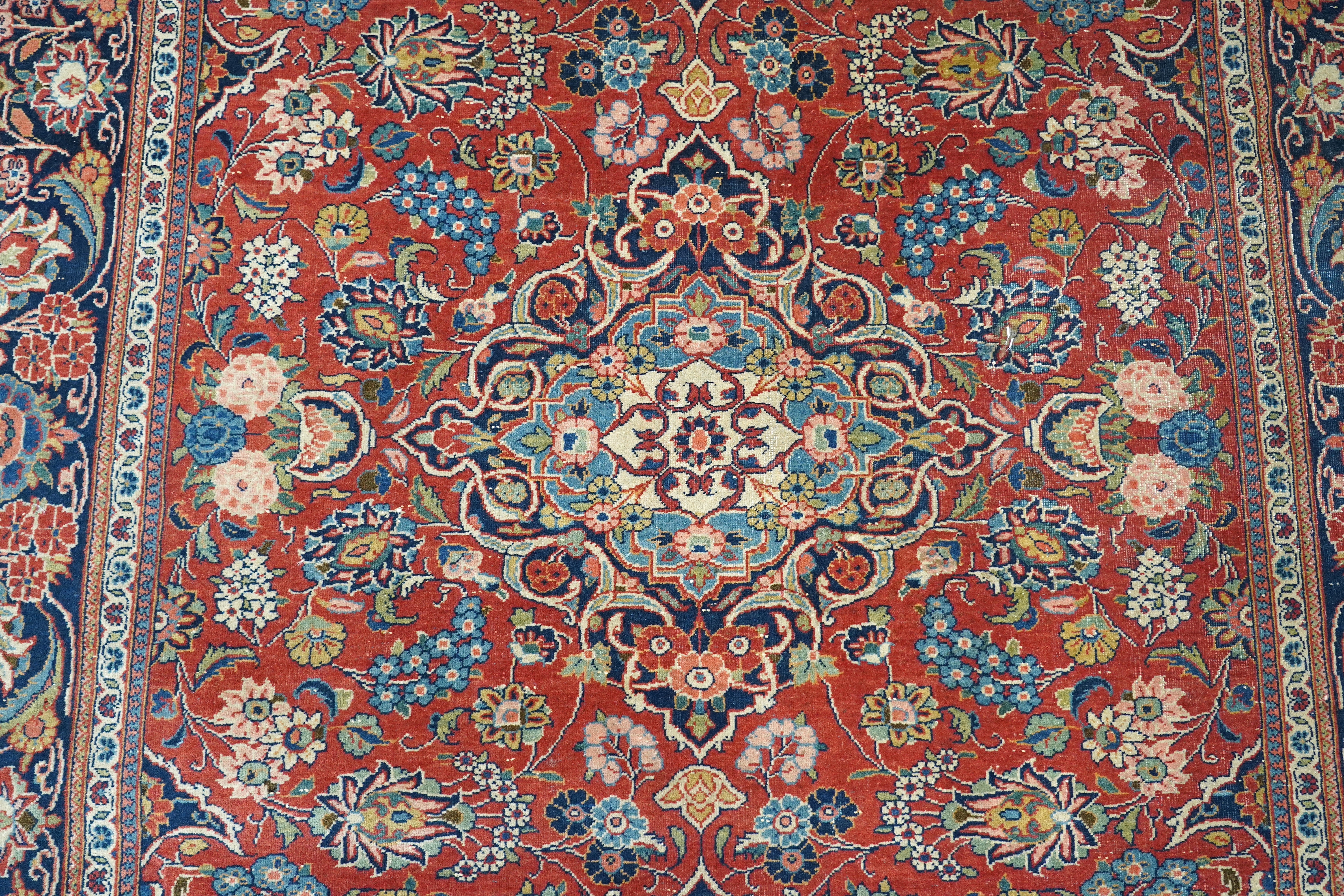 A pair of antique Tabriz brick red ground rugs, 200 x 136cm. Condition - fair